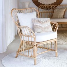 a living room with wicker furniture and white rugs on the floor in front of a mirror