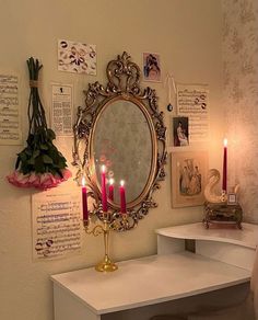 a vanity with candles and flowers on it in front of a mirror that has been placed on the wall