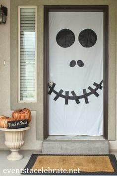 a front door decorated for halloween with a jack - o - lantern face