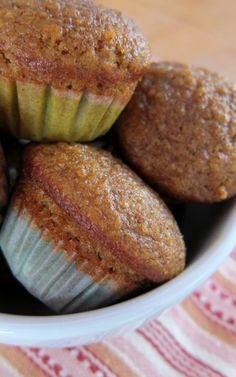 three muffins in a white bowl on a table