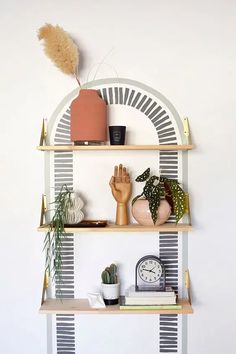 a shelf with some plants on it and a clock in the corner next to it