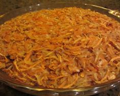 a glass dish filled with shredded cheese on top of a counter