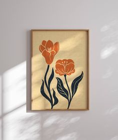 an orange and black flower on a beige background in a wooden frame hanging on the wall