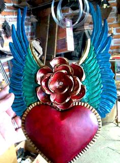 a heart with wings and a flower on it