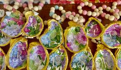 some colorful beads and necklaces on display in a store window ornament with flowers painted on them