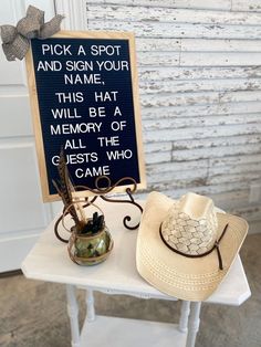 two hats are sitting on a table next to a sign that says pick a spot and sign your name