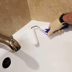 a person with gloves on is cleaning a sink