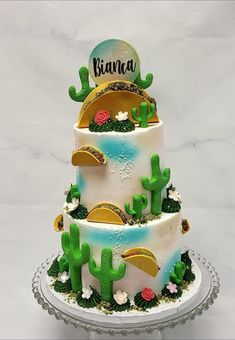 a three tiered cake decorated with cactus and succulents