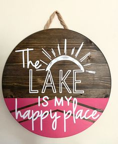 a wooden sign that says the lake is my happy place hanging from a rope on a wall