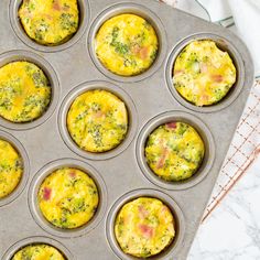 muffin tins filled with eggs and broccoli sitting on a counter top