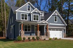 a large gray house with white trim and two car garages in front of it