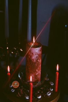 a lit candle sitting on top of a table next to some coffee beans and candles