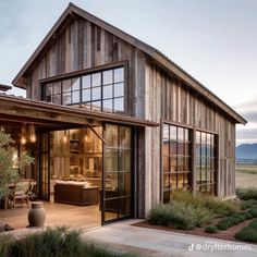 a large wooden building with glass doors and windows on the outside, surrounded by greenery