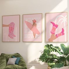 three pink posters hang on the wall above a green chair in front of a potted plant