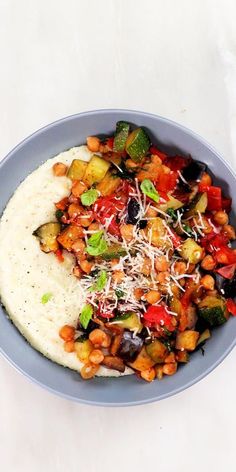 a blue bowl filled with food on top of a white table