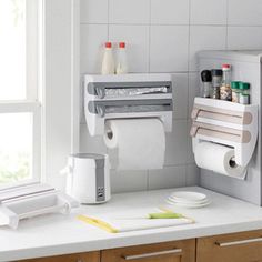 a kitchen with a sink, toilet paper dispenser and other items on the counter