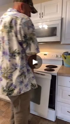 a man standing in front of an oven with the door open and his hand on the stove