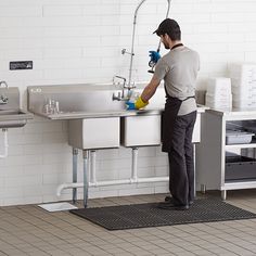 a man is washing his hands in the kitchen sink while wearing gloves and scrubs