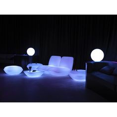 some lights that are sitting on the ground in front of couches and chairs with pillows