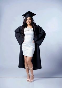 a woman in a graduation gown and cap posing for the camera with her hands on her hips