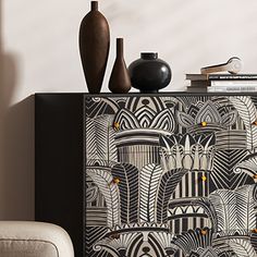 a black and white cabinet sitting next to a vase on top of a wooden table