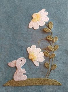 a close up of a piece of cloth with flowers and a bunny on it's back