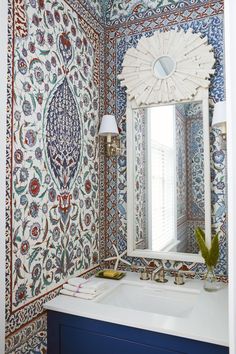 the bathroom is decorated in blue and white with an intricate wallpaper pattern on the walls