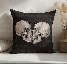 two human skull heads on a black pillow