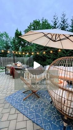 a birdcage sitting on top of a blue rug next to an open umbrella