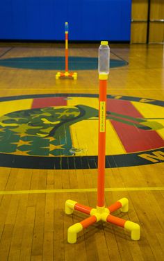 two orange and yellow poles on a basketball court