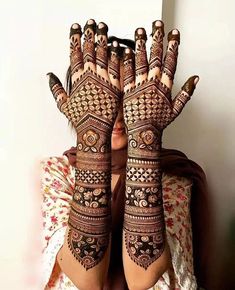 a woman with her hands covered in henna