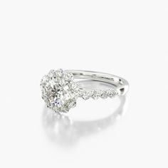 a white gold engagement ring with an oval cut diamond center and pave set shoulders