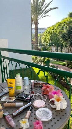 the table is covered with beauty products and flowers on it's side rail outside