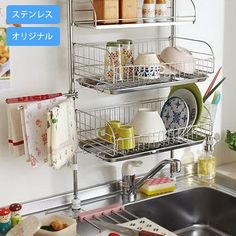 a kitchen sink filled with dishes next to a wall mounted dish drying rack and hanging utensils