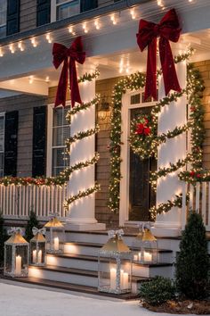 christmas decorations on the front porch of a house with lit garlands and wreaths