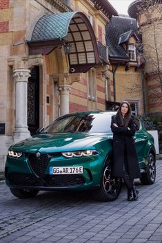 a woman standing next to a green car