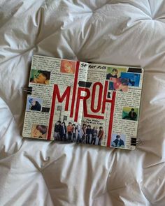 an open notebook with the word mrq on it laying on a white bed sheet