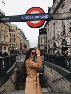 a woman taking a selfie in front of the underground sign