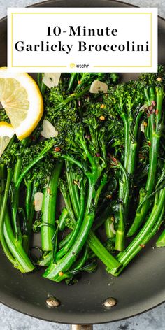 broccoli is being cooked in a pan with lemon wedges on the side