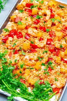 a sheet pan filled with shrimp and rice covered in cilantro sauce, garnished with parsley