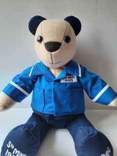 a teddy bear that is wearing a blue uniform