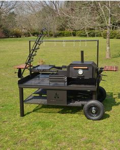 an outdoor grill on wheels in the grass