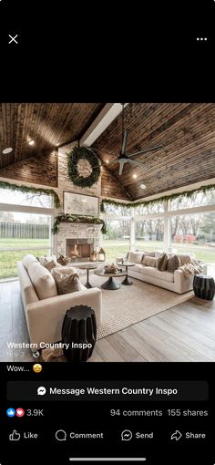 a living room filled with furniture and a fire place in the middle of a wooden ceiling