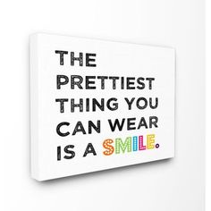 the prettiest thing you can wear is a smile canvas print on white wall