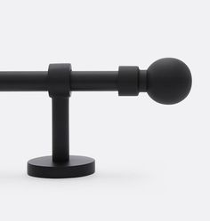 a black metal pole with two round knobs on it's end and one ball at the top