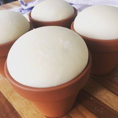 four bowls filled with food sitting on top of a wooden table