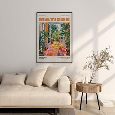 a living room with a couch, table and potted plant on the side wall