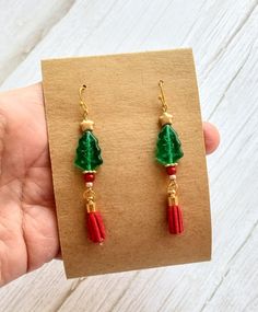 These handmade Christmas Tree goldtone earrings sparkle with beads in red, green and gold--and suede tassels, too! Earrings come with silicone earnuts for extra security. Festive Dangle Tassel Earrings With Beads, Festive Tassel Earrings With Dangling Beads, Red Dangle Tassel Earrings For Festive Occasions, Festive Red Tasseled Jewelry, Red Tassel Earrings For Festive Occasions, Handmade Christmas Tree, Tree Earrings, Christmas Tree Earrings, Suede Tassel