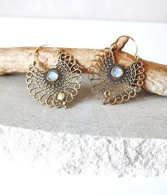 The Boho earrings are made of golden brass and are decorated with a real moonstone. They have a delicate mandala design with a geometric pattern. The embellishments give the earrings a special boho touch. Material: brass Stone: Moonstone Length including pendant: 50 mm Diameter: 35mm Color gold Weight per earring: 5g The earrings are handmade in India by a small jewelry manufacturer. Every stone sparkles differently, which is why every piece is unique. The gold earrings are delivered as a pair (2 pieces). They come nicely packaged, so they would definitely be nice as a gift. Care instructions: You can polish your earrings from time to time with a soft cloth. If they become dull, half a lemon will help! Sprinkle these with coarse-grained salt and rub the material with it. Finally, wipe with Bohemian Moonstone Jewelry For Festivals, Bohemian Gold Moonstone Jewelry, Bohemian Bronze Earrings With Intricate Design, Bohemian Moonstone Earrings Nickel-free, Bohemian Moonstone Earrings Nickel Free, Bohemian Moonstone Drop Earrings, Bohemian Brass Earrings With Intricate Design, Bohemian Moonstone Earrings, Bohemian Bronze Filigree Earrings