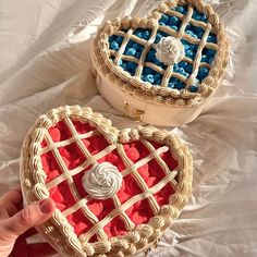 two heart shaped cakes sitting on top of a white cloth covered table next to each other